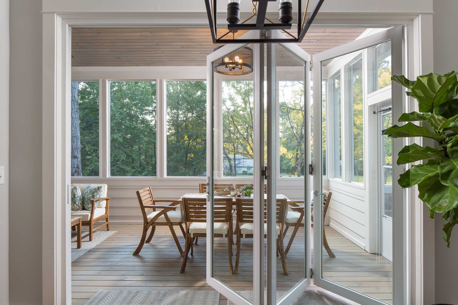 Screened porch seen through open folding glass doors — Austin Garner Rd, custom home built by Ironwood Construction Group