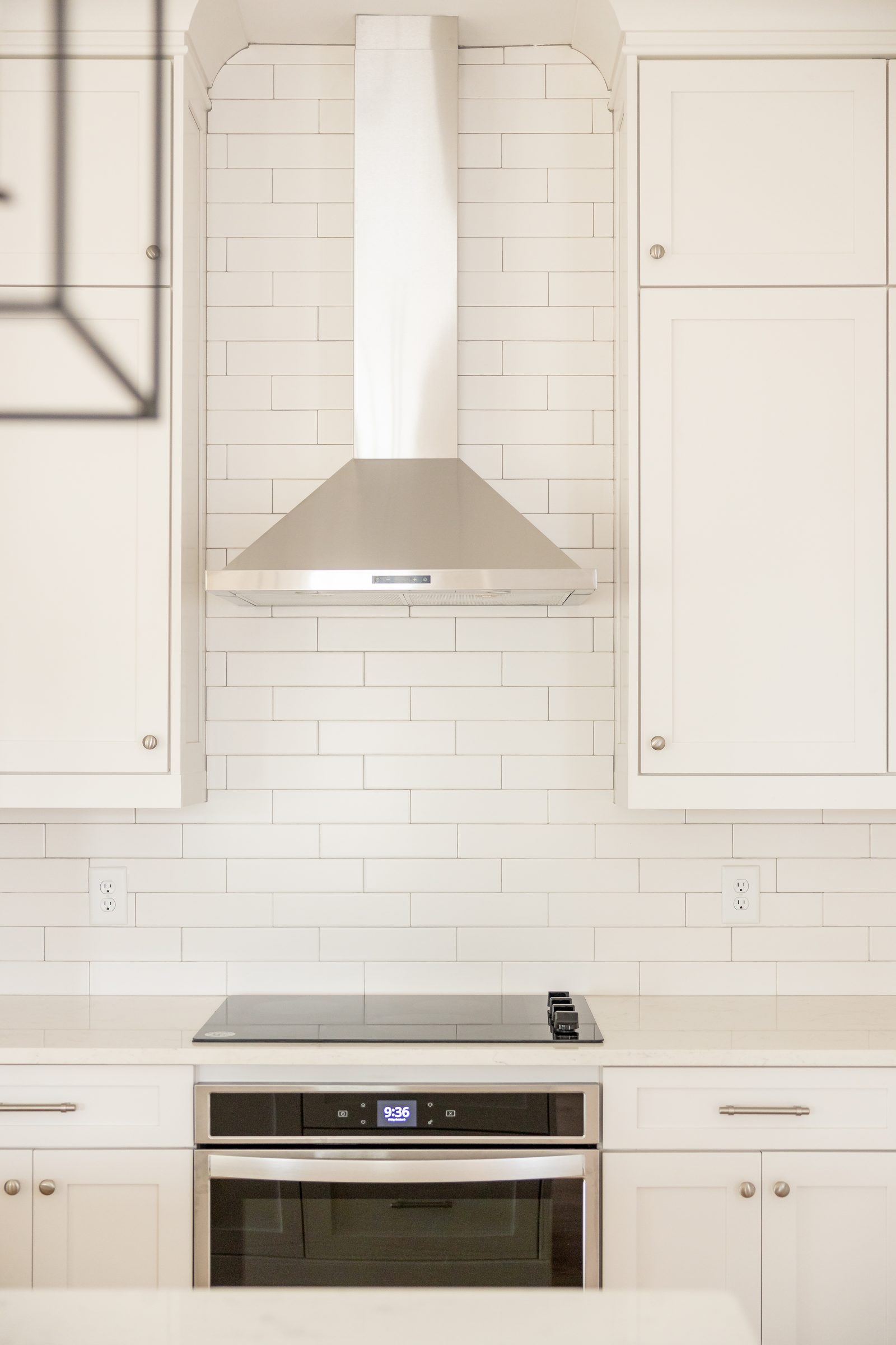 Kitchen range wall with subway tile and stainless hood — Shadburn Ferry, custom home built by Ironwood Construction Group in Buford, Georgia