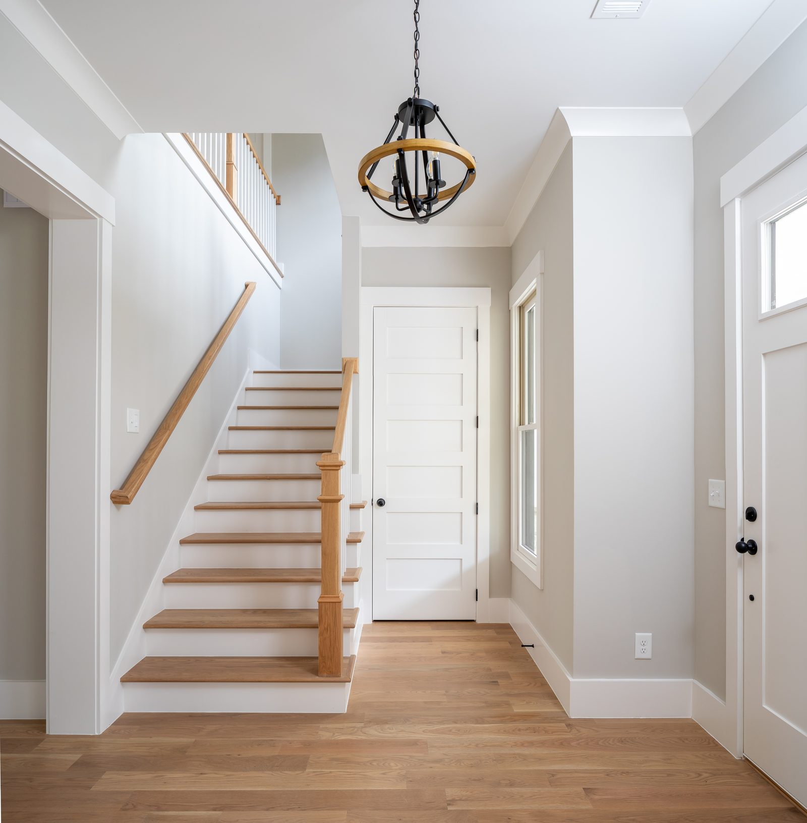 Entry foyer with open staircase and white-oak floor — Shadburn Ferry, custom home built by Ironwood Construction Group in Buford, Georgia